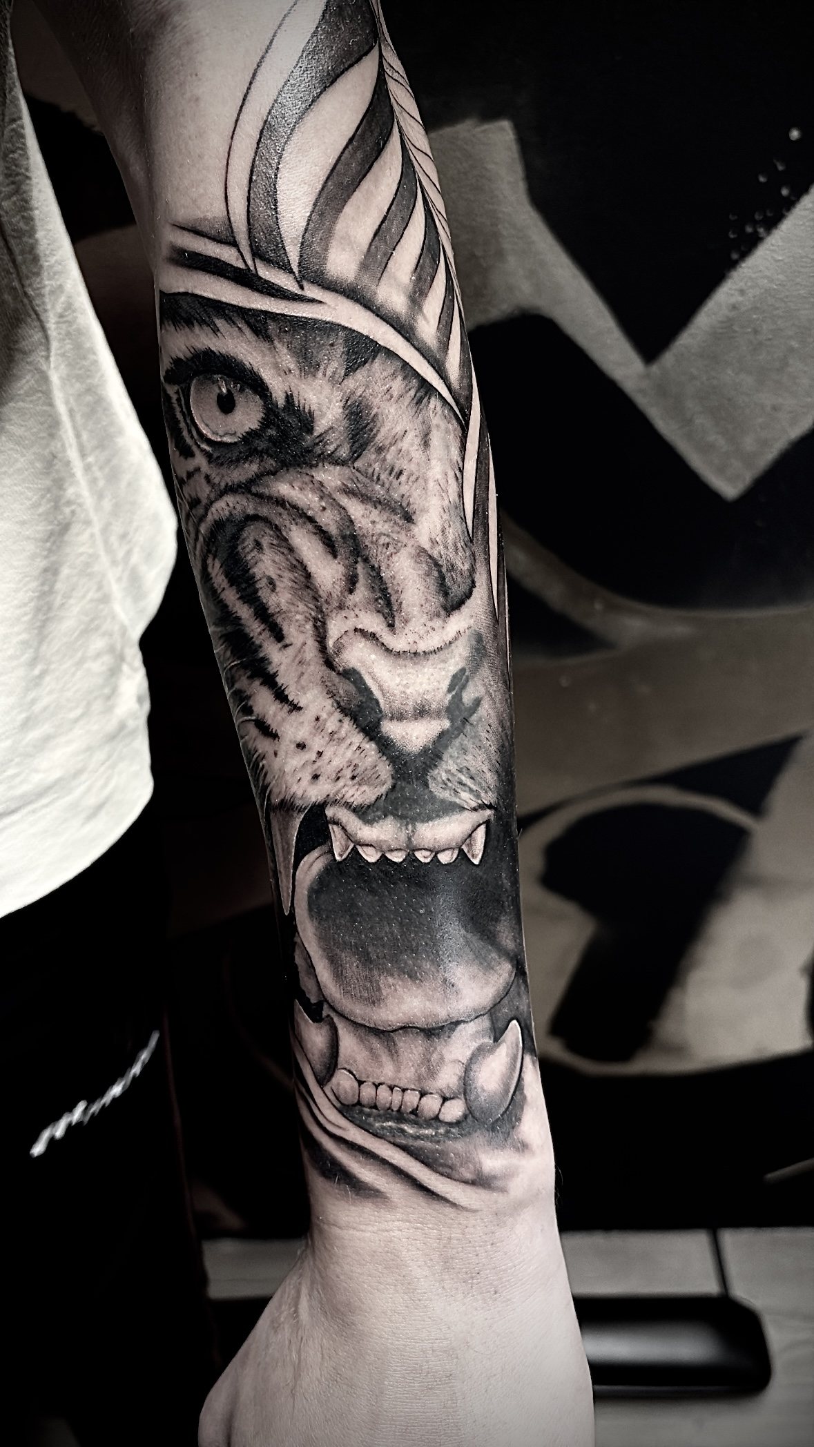 Tattoo van een tijgerkop in zwart en grijs op de onderarm